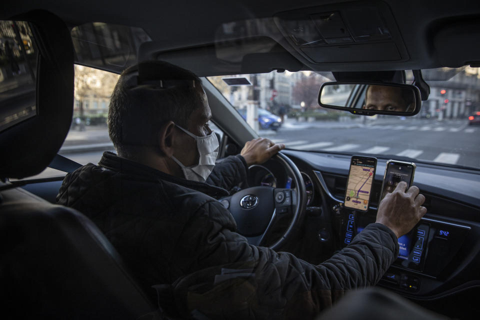 PARIS, FRANCE - FEBRUARY 27:  A Uber driver checks his phone as he drives on February 27, 2021 in Paris, France. Despite the development of Covid-19 vaccine campaigns to prevent infections, health experts still warn that restrictions and safety measures - including non-essential travel will still be needed for 2021. (Photo by Siegfried Modola/Getty Images)