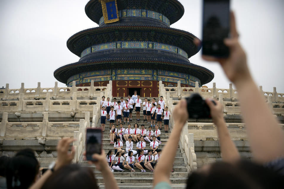 Students pose for a group photo at the Temple of Heaven in Beijing, Saturday, July 18, 2020. Authorities in a city in far western China have reduced subways, buses and taxis and closed off some residential communities amid a new coronavirus outbreak, according to Chinese media reports. They also placed restrictions on people leaving the city, including a suspension of subway service to the airport. (AP Photo/Mark Schiefelbein)