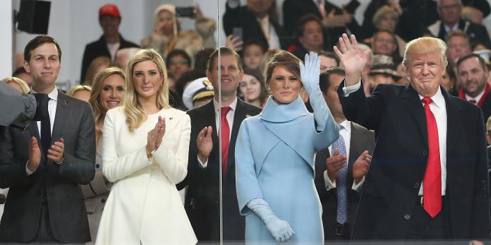 President Donald Trump waving with his family inside the inaugural parade reviewing stand in front of the White House on January 20, 2017 in Washington, DC.
