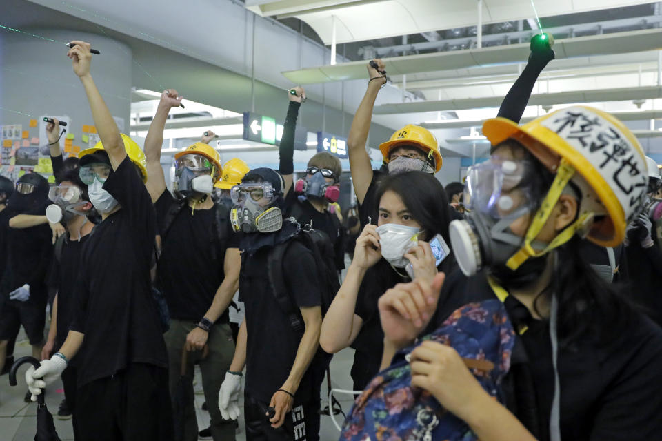 Demonstrators shine laser pointers during a protest at the Yuen Long MTR station in Hong Kong, Wednesday, Aug. 21, 2019. Hong Kong riot police faced off briefly with protesters occupying a suburban train station Wednesday evening following a commemoration of a violent attack there by masked assailants on supporters of the anti-government movement. (AP Photo/Kin Cheung)