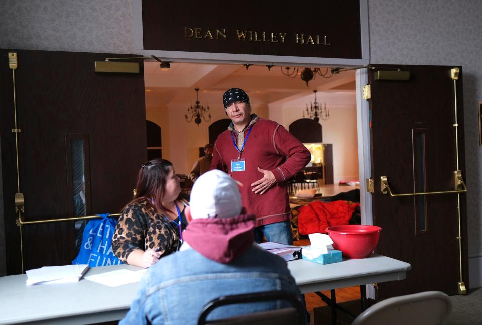 Hewitt "James" West II, standing, and Tess Emory, left, sign in a person Monday, Jan. 30, 2023, at St. Paul's Episcopal Cathedral, which has opened its doors to the homeless for this stretch of extremely cold weather.