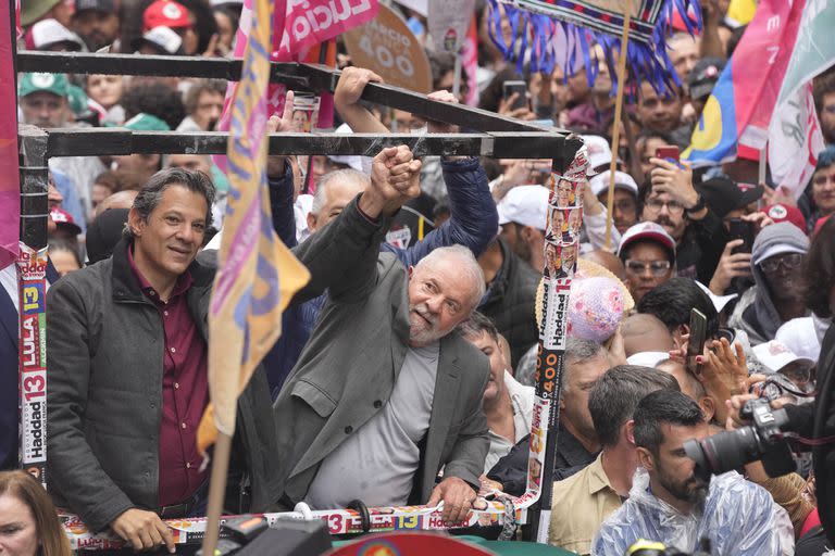 El candidato a gobernador del Partido de los Trabajadores, Fernando Haddad, a la izquierda, y el expresidente de Brasil, Luiz Inácio Lula da Silva, quien se postula para presidente, levantan los brazos durante un mitin de campaña un día antes de las elecciones generales del país, en San Pablo