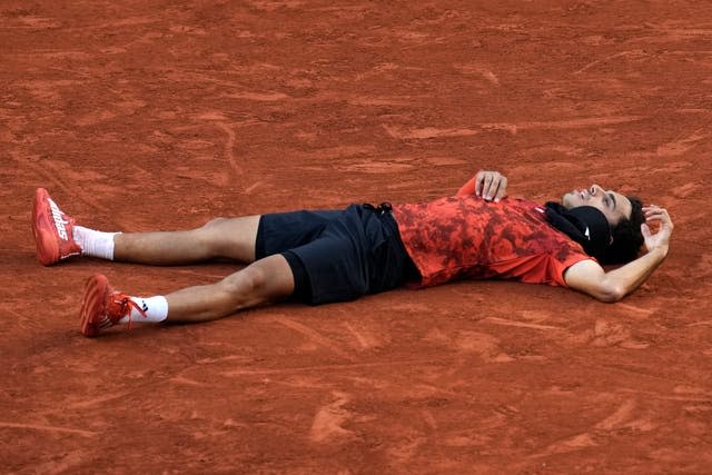 Francisco Cerundolo lies on the court after beating Taylor Fritz 