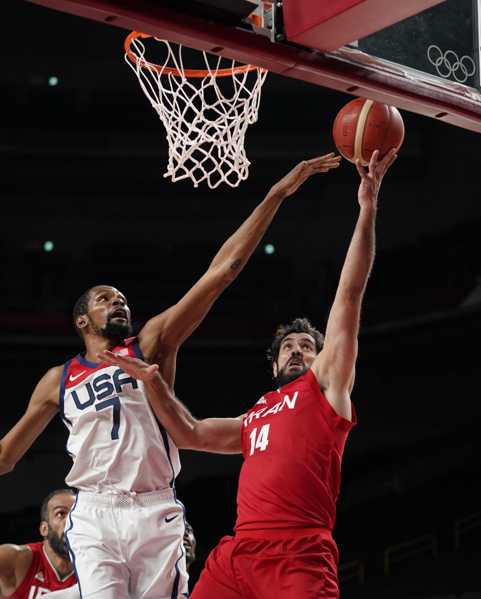 Iran's Mohammadsamad Nik Khahbahrami (14), right, scores ahead of United States' Kevin Durant (7) during men's basketball preliminary round game at the 2020 Summer Olympics, Wednesday, July 28, 2021, in Saitama, Japan. (AP Photo/Charlie Neibergall)