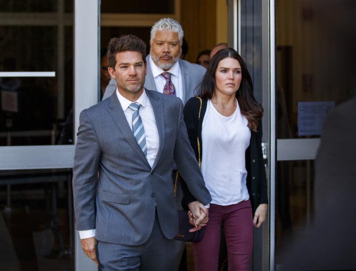 NEWPORT BEACH, CALIF. -- FRIDAY, FEBRUARY 7, 2020: Newport Beach surgeon Grant Robicheaux, center, and his girlfriend Cerissa Riley leave the Harbor Justice Center where Judge Gregory Jones delayed dismissing rape charges against the doctor and girlfriend, saying politics has 'infected this case' in Newport Beach, Calif., on Feb. 7, 2020. (Allen J. Schaben / Los Angeles Times)