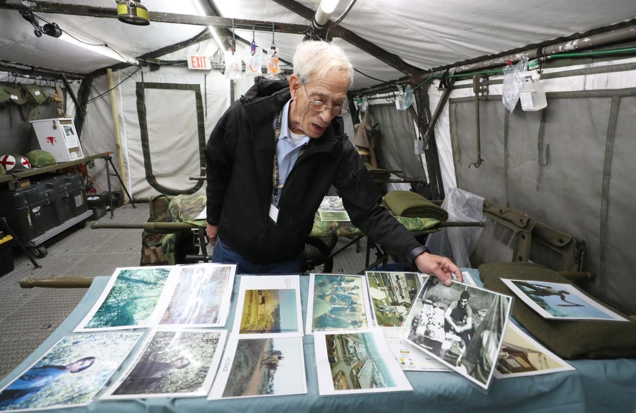 Vietnam War veteran Ted Mathies, 75, holds up a 1969 photo of himself as a combat medic in the U.S. Army. He owns and operates the Medic’s Corner exhibit at MAPS Air Museum in Green.