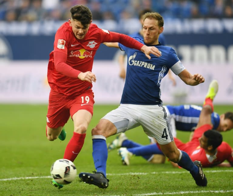 Schalke's defender Benedikt Hoewedes and Leipzig's midfielder Oliver Burke fight for the ball on April 23, 2017