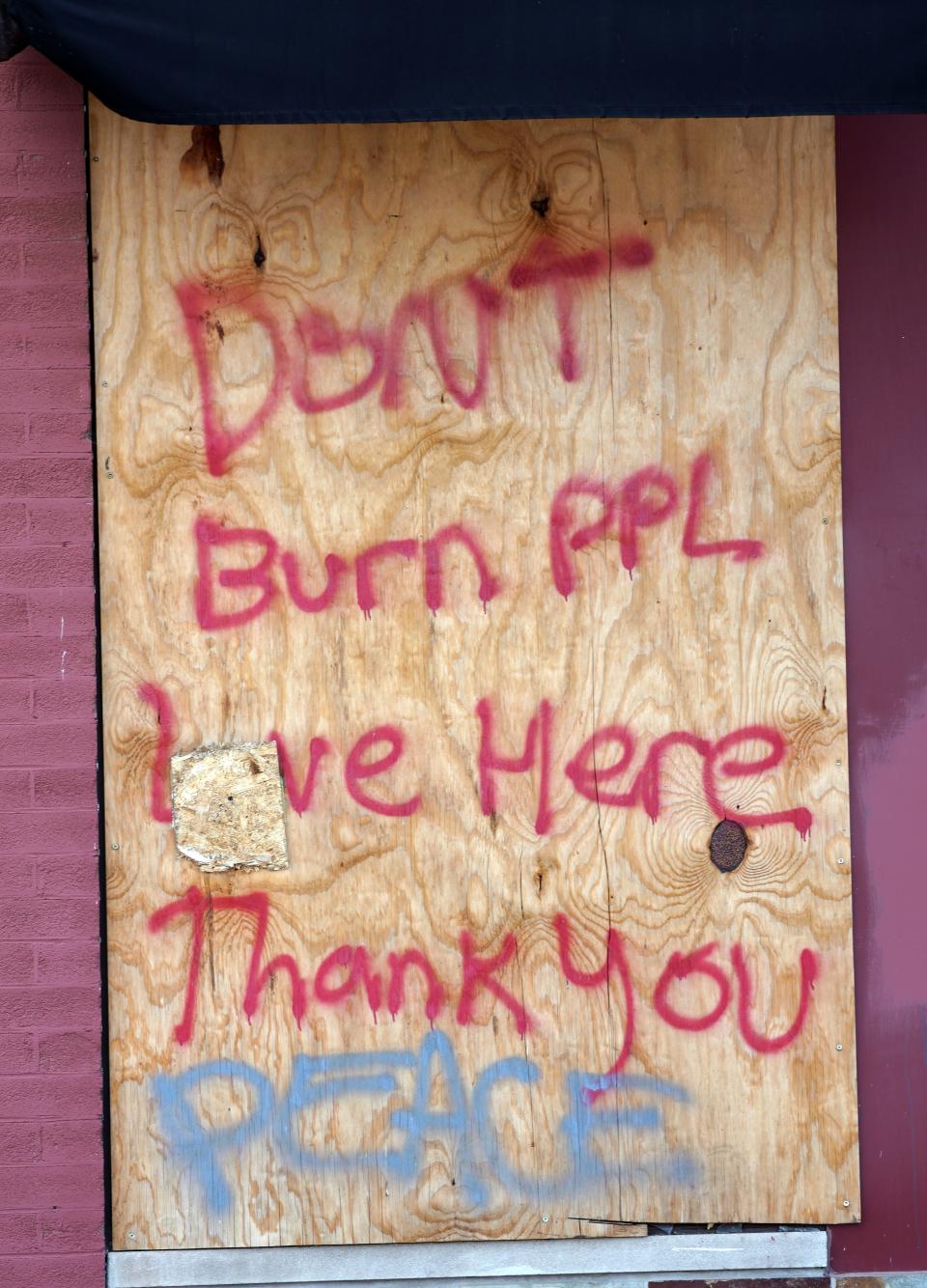 Plywood covers windows destroyed during riots after the death of George Floyd in Minneapolis. Such messages were common as people pleaded for their homes and businesses to be spared from arsonists.