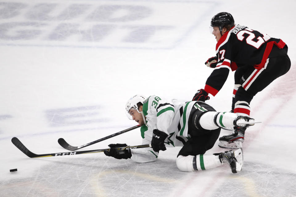 Dallas Stars center Joel L'Esperance (38) and Chicago Blackhawks defenseman Adam Boqvist (27) compete for the puck during the first period of an NHL hockey game Thursday, April 8, 2021, in Chicago. (AP Photo/Jeff Haynes)