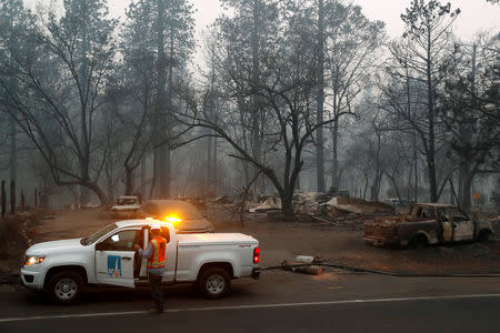 Employees of Pacific Gas & Electric (PG&E) work in the aftermath of the Camp Fire in Paradise, California, U.S., November 14, 2018. REUTERS/Terray Sylvester