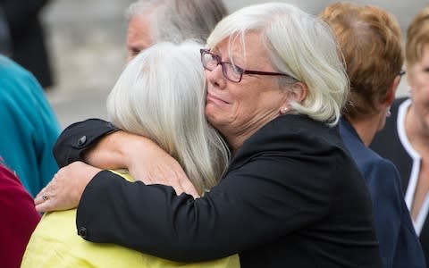 Families members embrace after the publication of the inquiry report - Credit: Dominic Lipinski /PA