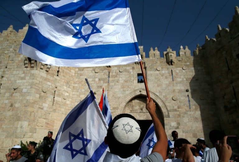 Israelis wave flags outside Damascus Gate in Jerusalem's old city on June 5, 2016 as they celebrate Jerusalem Day