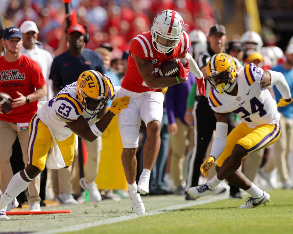 Mississippi wide receiver Jordan Watkins (11) is tackled by LSU linebacker Micah Baskerville (23) during the first half at Tiger Stadium.