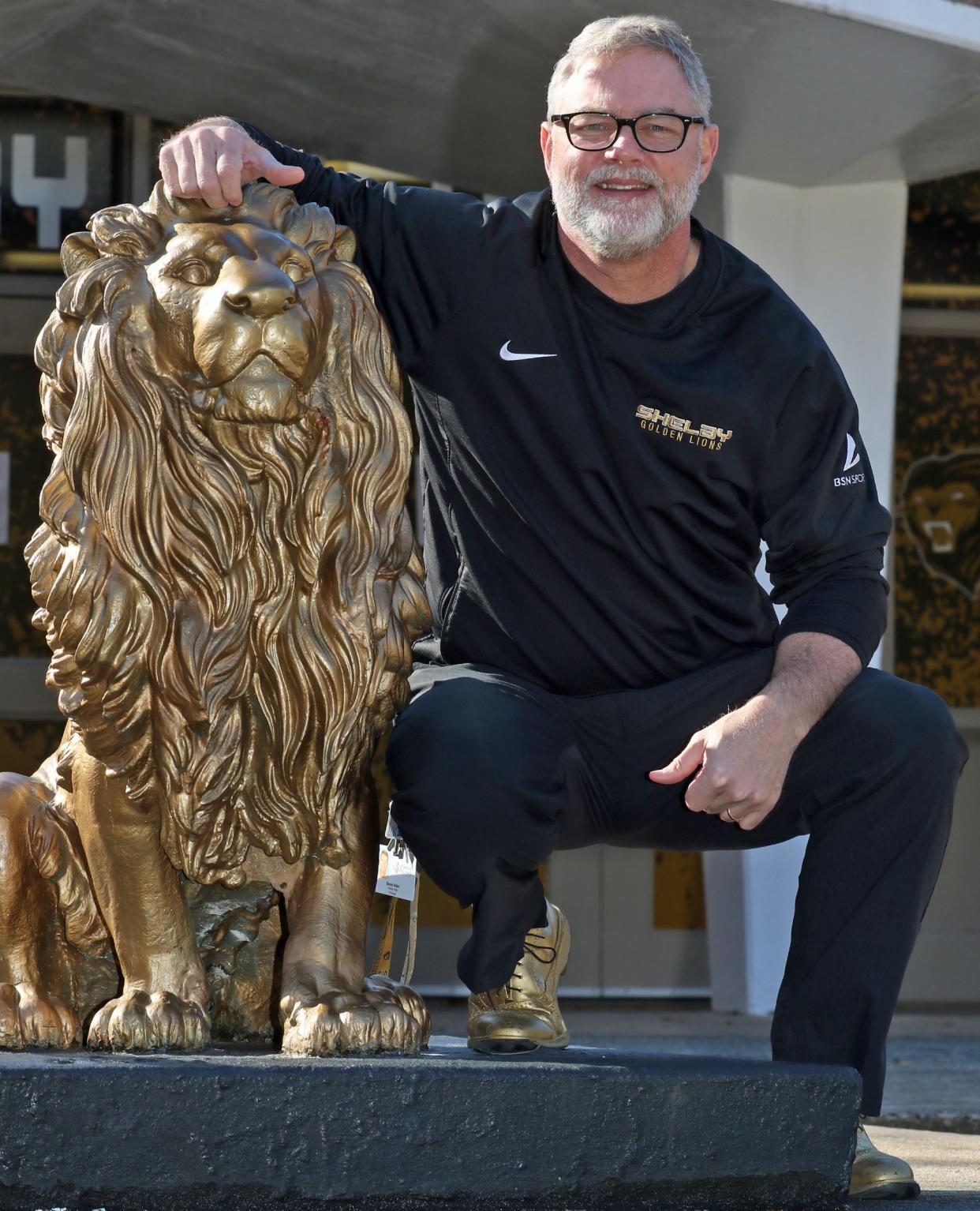 Principal David Allen poses next to the lion statue outside Shelby High School Friday morning, Jan. 13, 2023.