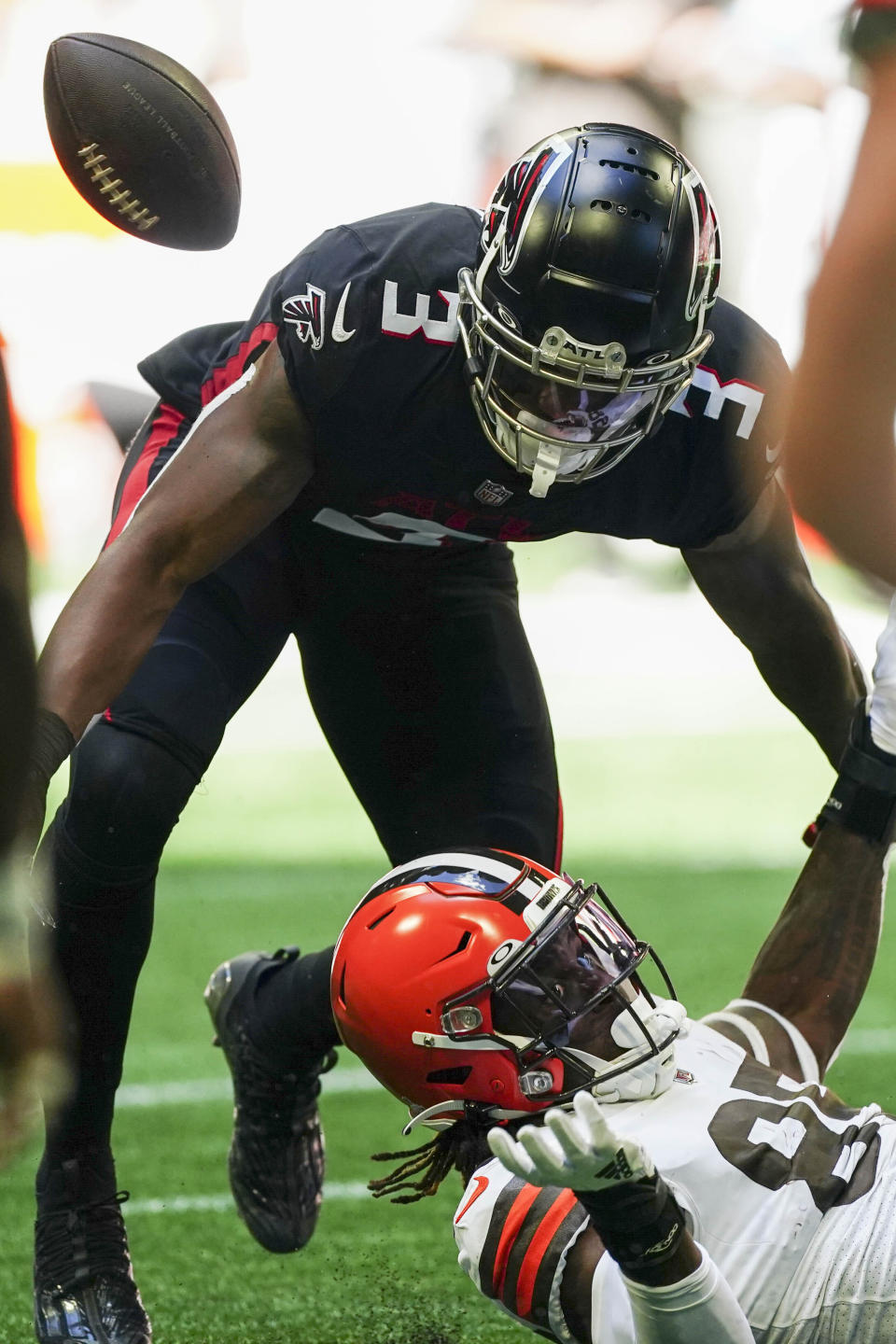 Cleveland Browns tight end David Njoku (85) fumbles after his catch against Atlanta Falcons linebacker Mykal Walker (3) during the first half of an NFL football game, Sunday, Oct. 2, 2022, in Atlanta. (AP Photo/John Bazemore)