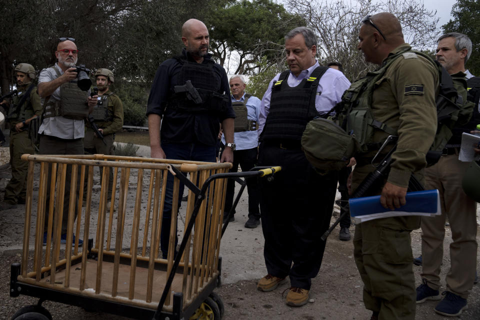 Former New Jersey Governor Chris Christie, center right, looks at a baby carriage as he visits Kibbutz Kfar Azza, near the Israel-Gaza border, the site of an Oct. 7 massacre by Hamas, with Israel's Knesset Speaker Amir Ohana, left and Israeli Army Maj. Diamond, right, Sunday, Nov. 12, 2023. (AP Photo/Maya Alleruzzo)