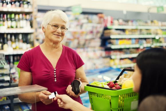 An elderly woman buying groceries.