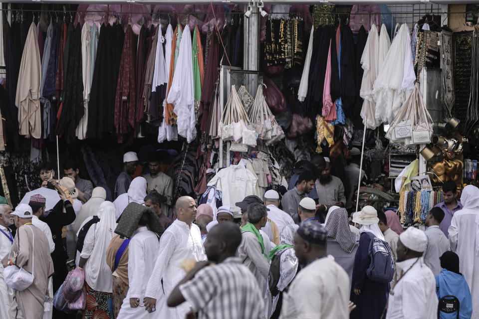 Muslim pilgrims buy souvenirs outside the Grand Mosque, during the annual hajj pilgrimage, in Mecca, Saudi Arabia, Friday, June 23, 2023. Muslim pilgrims are converging on Saudi Arabia's holy city of Mecca for the largest hajj since the coronavirus pandemic severely curtailed access to one of Islam's five pillars. (AP Photo/Amr Nabil)