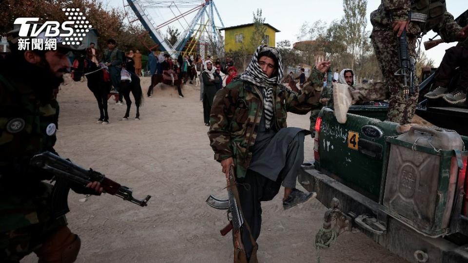 塔利班武裝份子手持步槍，搭乘招牌皮卡車參觀遊樂園。（圖／達志影像路透社）