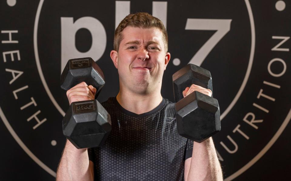 Jack Rear lifting dumbbells at a gym