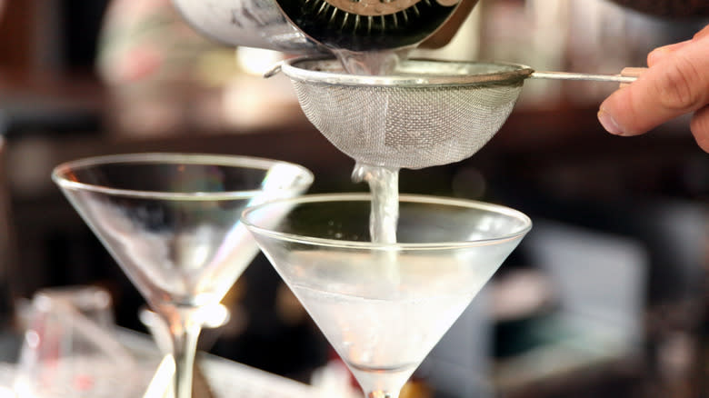 martini being strained into glass