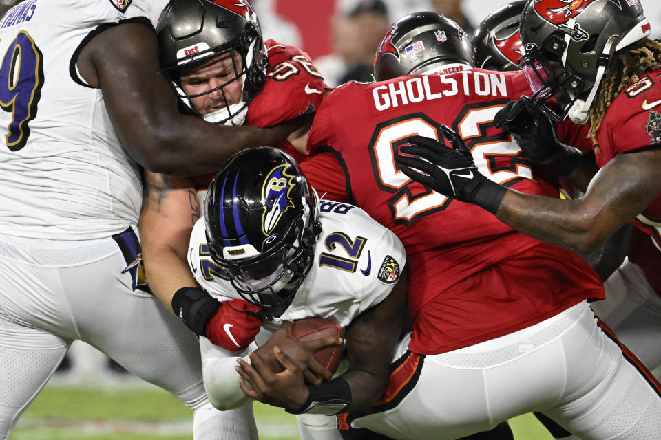 Tampa Bay Buccaneers defensive end William Gholston, second from right, sacks Baltimore Ravens quarterback Anthony Brown, center, as defensive tackle Greg Gaines grabs Brown during the second half of an NFL preseason football game Saturday, Aug. 26, 2023, in Tampa, Fla. (AP Photo/Jason Behnken)