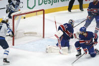 The puck goes into the net past Montreal Canadiens goaltender Jake Allen for a goal by Winnipeg Jets' Pierre-Luc Dubois (not shown) as Canadiens' Joel Armia looks on during overtime in NHL hockey game action in Montreal, Thursday, March 4, 2021. (Paul Chiasson/The Canadian Press via AP)