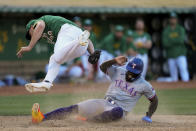 Oakland Athletics pitcher Kyle Muller, left, tags out Texas Rangers' Adolis García at home plate during the eighth inning in the second baseball game of a doubleheader Wednesday, May 8, 2024, in Oakland, Calif. (AP Photo/Godofredo A. Vásquez)