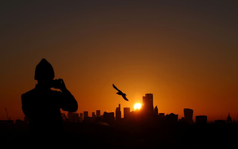 FILE PHOTO: A person takes a photograph of the London skyline from Primrose Hill