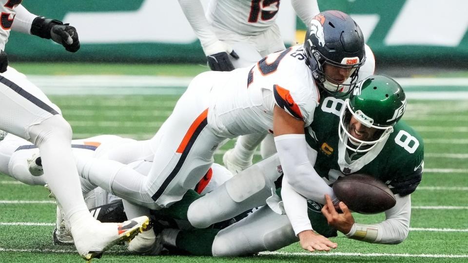 Denver Broncos linebacker Jonah Elliss (52) and Denver Broncos defensive tackle Malcolm Roach (97) sack New York Jets quarterback Aaron Rodgers (8) during the fourth quarter at MetLife Stadium. 