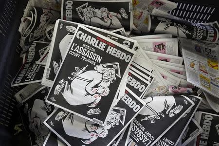 Copies of the latest edition of French weekly newspaper Charlie Hebdo with the title "One year on, The assassin still on the run" Paris, France, January 4, 2016. REUTERS/Benoit Tessier