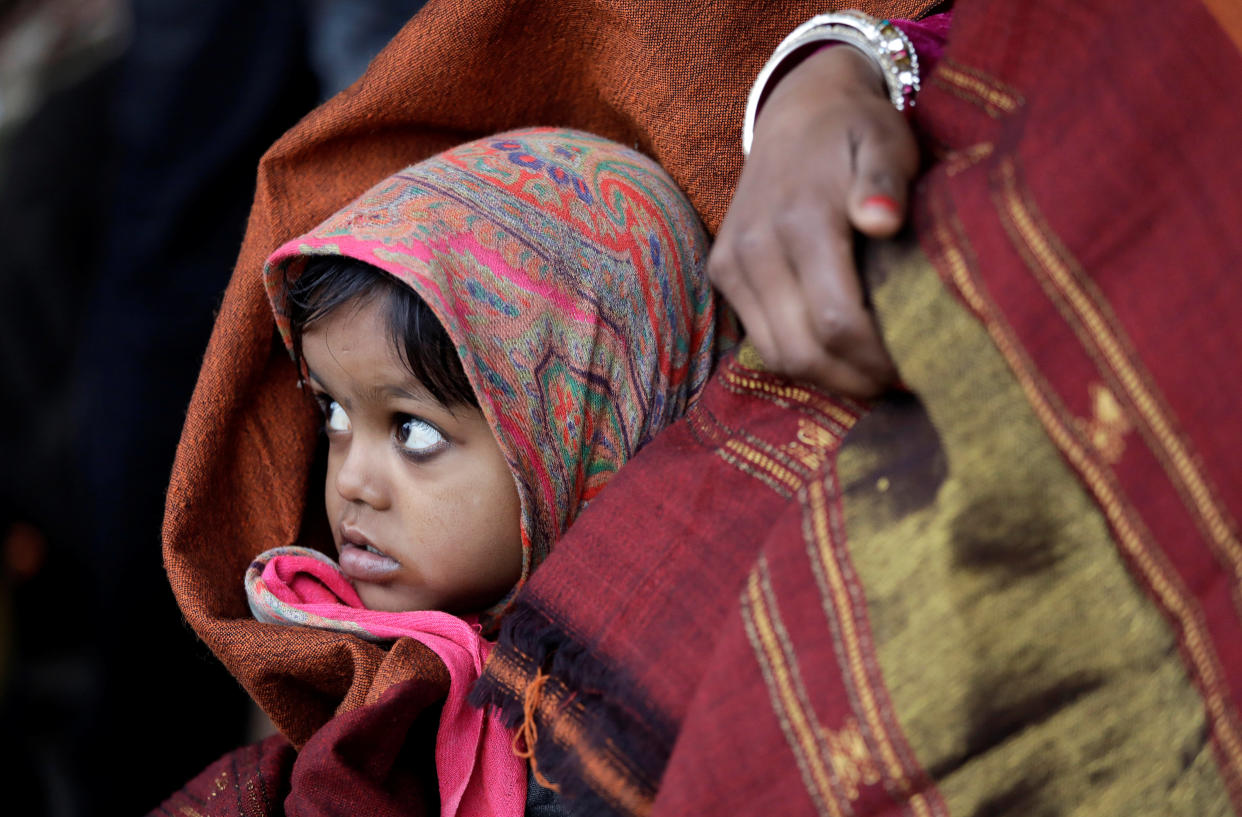 A little girl wrapped in a shawl waits along with her mother at a railway station in New Delhi, India, on the cold winter morning of Jan. 3, 2018. (Photo: Saumya Khandelwal / Reuters)