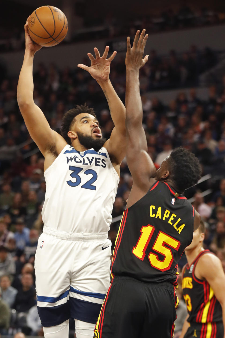 Minnesota Timberwolves center Karl-Anthony Towns (32) shoots over Atlanta Hawks center Clint Capela (15) in the first quarter of an NBA basketball game Wednesday, March 22, 2023, in Minneapolis. (AP Photo/Bruce Kluckhohn)