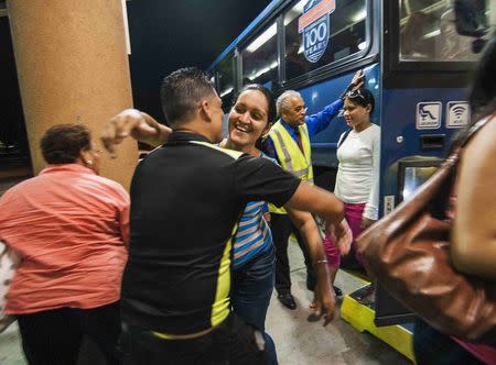 Cuban migrant Mailin Perez (3rd L) is greeted by her husband Jose Caballero after arriving via Mexico at a bus station in Austin, Texas September 25, 2014. REUTERS/Ashley Landis