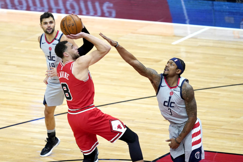 Chicago Bulls' Zach LaVine shoots over Washington Wizards' Bradley Beal (3) as Raul Neto watches during the first half of an NBA basketball game Monday, Feb. 8, 2021, in Chicago. (AP Photo/Charles Rex Arbogast)