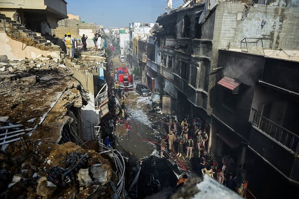 Rescue workers gather at the site after a Pakistan International Airlines aircraft crashed in a residential area in Karachi.