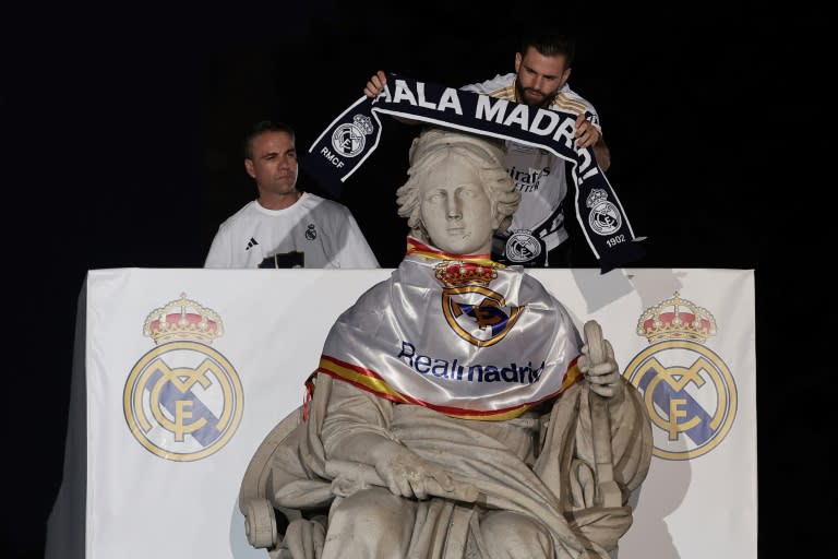 El capitán del Real Madrid Nacho Fernández le pone una bufanda a la estatua de la Cibeles en la celebración de la Liga de Campeones, este domingo 2 de junio en la capital española (Thomas COEX)