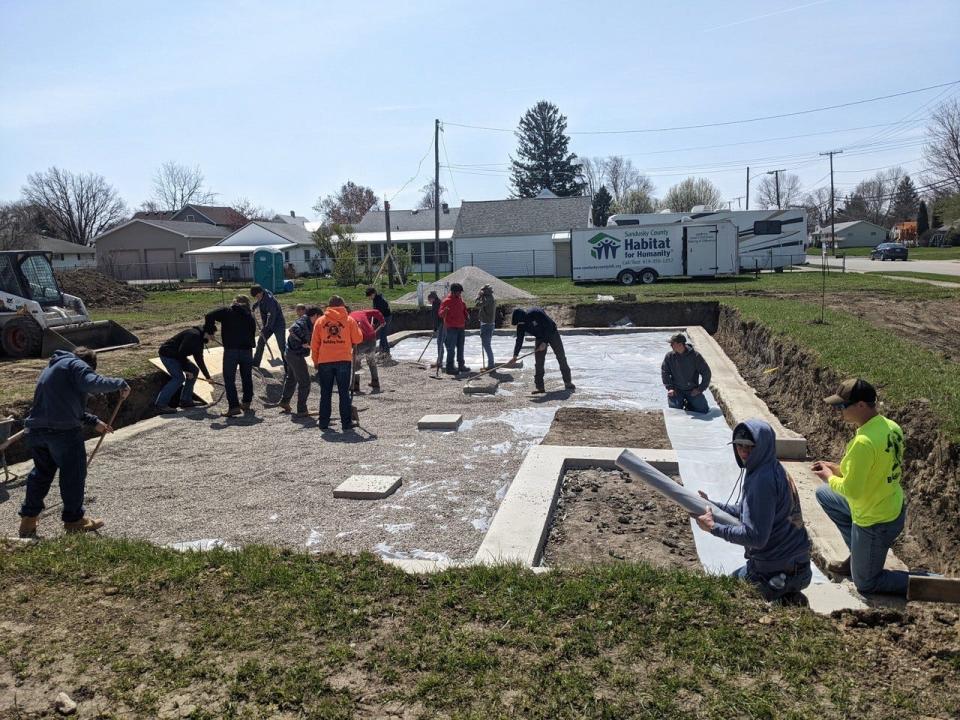 “Vanguard”  students from Vanguard’s Building Trades and Electrical Trades programs assist with the foundation at the Habitat build in Fremont.