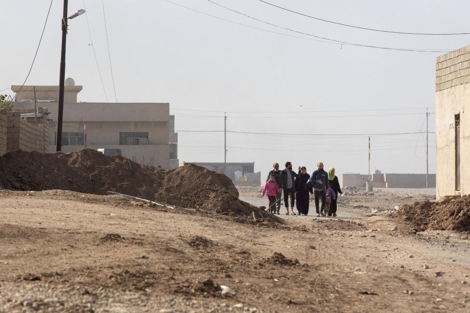 Civilians fleeing fighting between Islamic State group militants and Iraqi forces cross the frontline from the Samah neighborhood of Mosul in this Nov. 6, 2016 photo taken in Gogjali, Iraq in this Nov. 6, 2016 photo. Residents of Samah described one of the most horrific days they experienced under IS rule, saying that in the summer, the militants forced everyone in the neighborhood to watch as they stoned a woman to death for alleged adultery. (AP Photo/Nish Nalbandian)