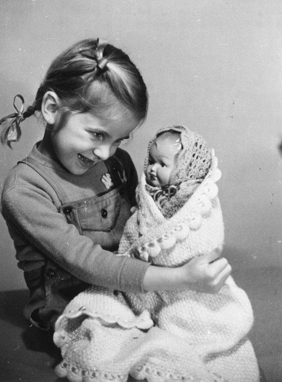 A girl plays with a baby doll in 1950.