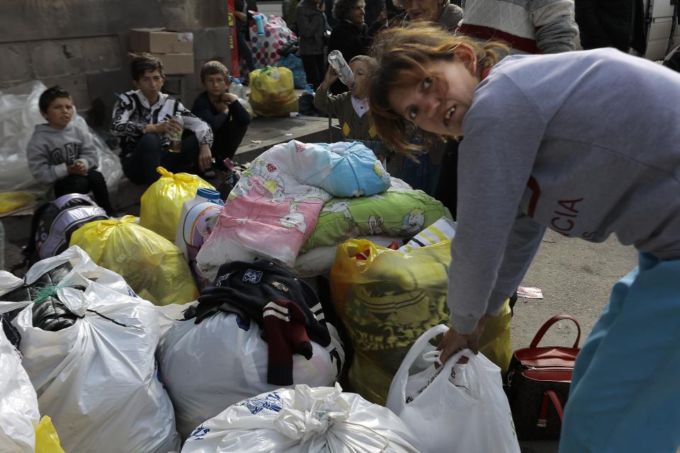 Ethnic Armenian children from Nagorno-Karabakh sit next to their belongings near a tent camp after arriving to Armenia's Goris in Syunik region, Armenia, on Saturday, Sept. 30, 2023. Armenian officials say that by Friday evening over 97,700 people had left Nagorno-Karabakh. The region's population was around 120,000 before the exodus began. (AP Photo/Vasily Krestyaninov)