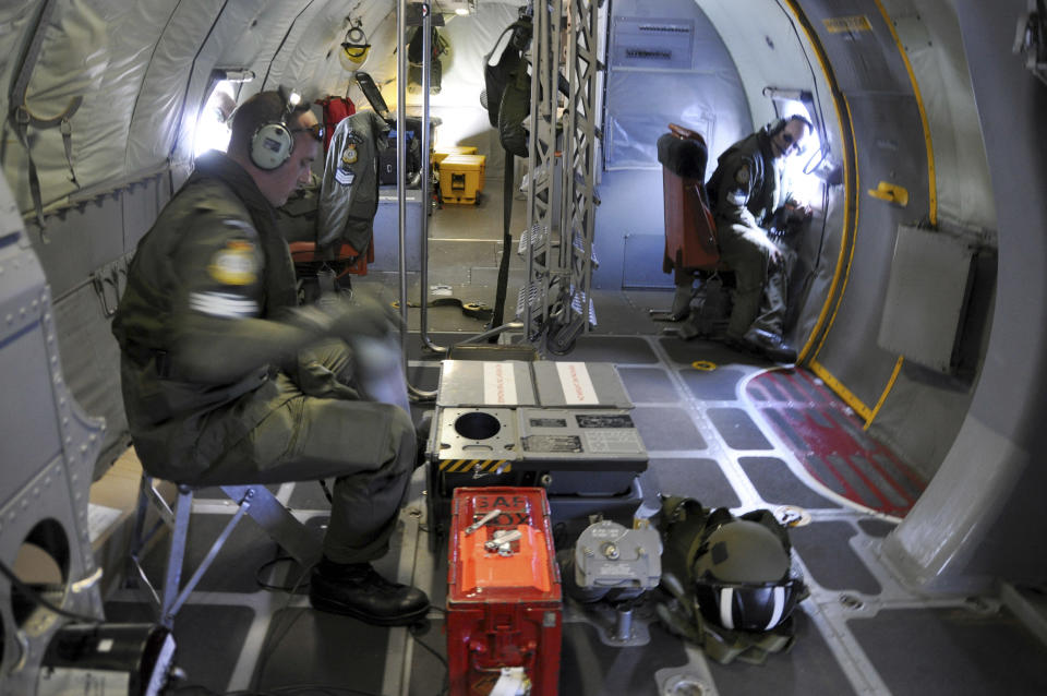 In this Tuesday, April 1, 2014 photo made available Thursday, April 3, 2014, crewmen on a Royal New Zealand Air Force P-3 Orion Rescue Flight 795 search for debris from the missing Malaysia Airlines Flight MH370 in southern Indian Ocean, 1,500 kilometers (932 miles) northwest of Perth, Australia. No trace of the Boeing 777 has been found nearly a month after it vanished in the early hours of March 8 on a flight from Kuala Lumpur to Beijing with 239 people on board. (AP Photo/Kim Christian, POOL)