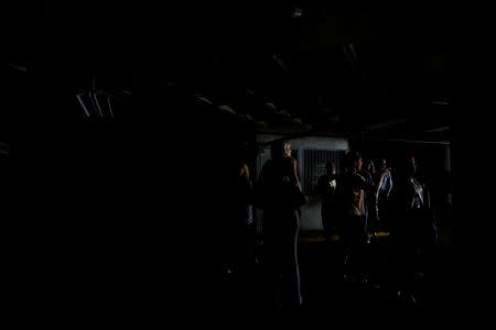 People walk at the parking garage of a building as they evacuate it during a blackout in Caracas, Venezuela March 25, 2019. REUTERS/Carlos Garcia Rawlins