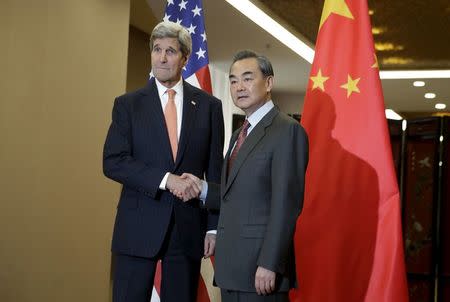 U.S. Secretary of State John Kerry (L) and Chinese Foreign Minister Wang Yi shake hands before their bilateral meeting at the Ministry of Foreign Affairs in Beijing January 27, 2016. REUTERS/Andy Wong/Pool