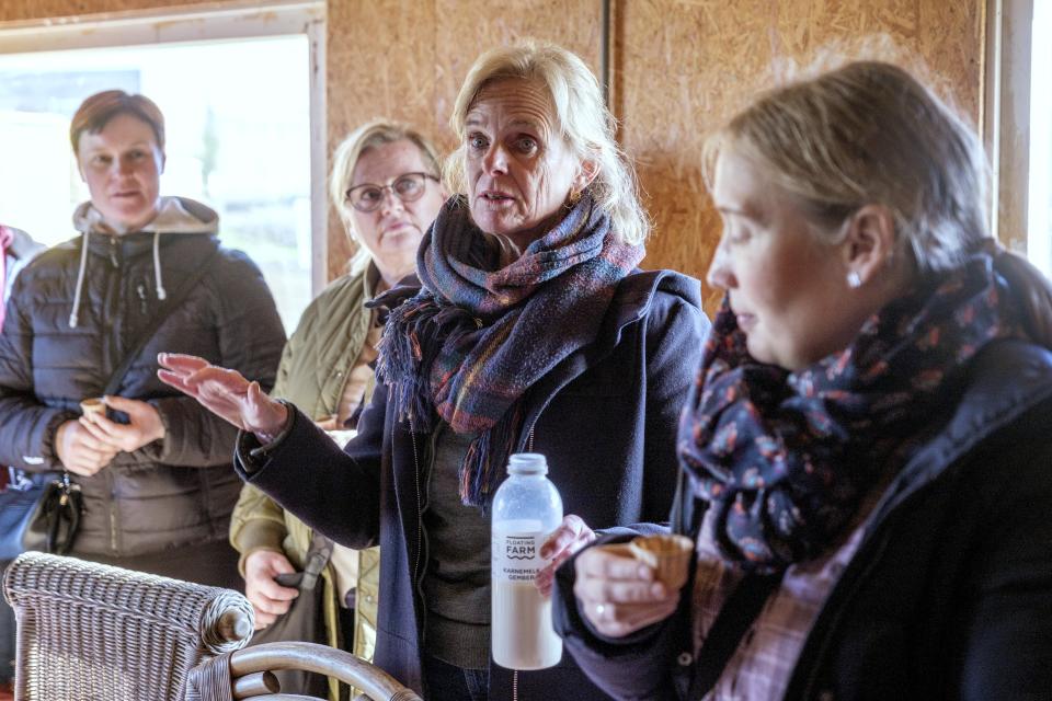 Minke van Wingerden, of the Floating Farm, holds some buttermilk at the shop on Nov. 7 2023, in Rotterdam, Netherlands. She sees agriculture on water as a viable response to flooding and rising sea levels and a way of bringing food production closer to consumers, meaning a lower carbon footprint. (AP Photo/Patrick Post)