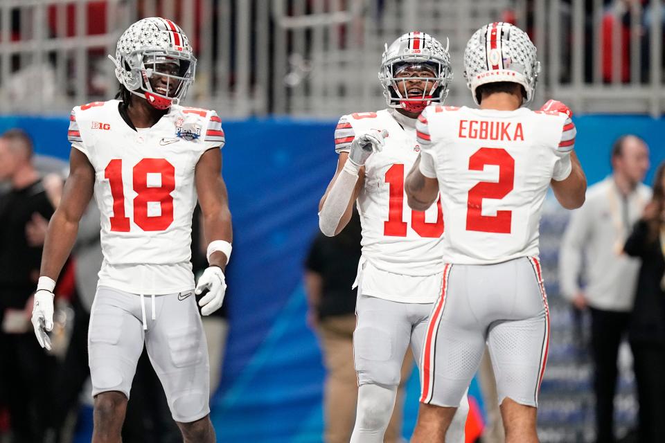 Dec 31, 2022; Atlanta, Georgia, USA; Ohio State Buckeyes wide receiver Marvin Harrison Jr. (18) and wide receiver Emeka Egbuka (2) celebrate a touchdown by wide receiver Xavier Johnson (10) during the first half of the Peach Bowl against the Georgia Bulldogs in the College Football Playoff semifinal at Mercedes-Benz Stadium. Mandatory Credit: Adam Cairns-The Columbus Dispatch