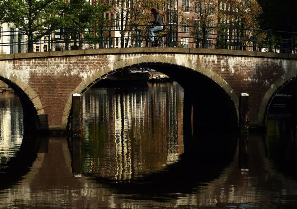 A cyclist makes his way across a canal in Amsterdam, Netherlands.