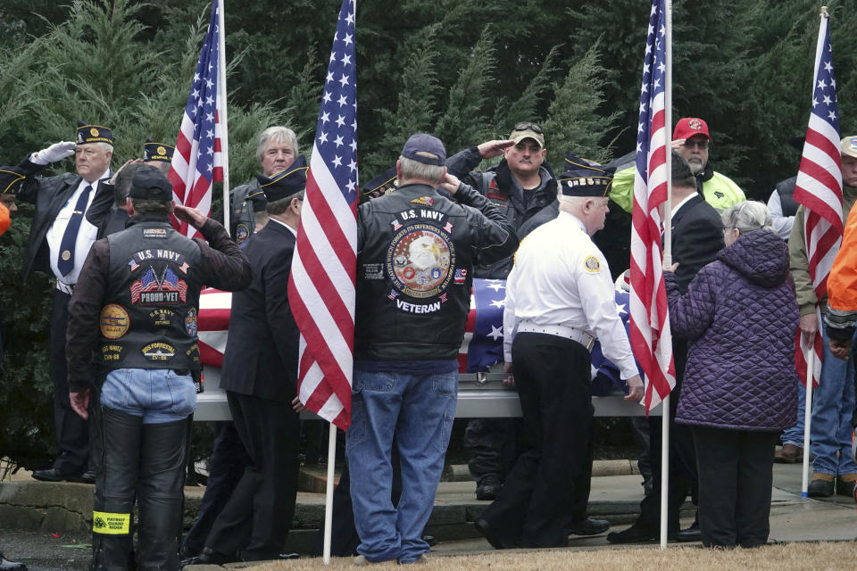 In this Jan. 17, 2019 photo, a flag draped coffin is moved during a funeral for three Memphis veterans, Wesley Russell, 76, Arnold Klechka, 71, Charles Fox, 60, who died this past fall and whose remains were unclaimed in Memphis, Tenn. Funeral homes, medical examiners, state and federal veterans’ affairs departments, and local veterans’ groups have combined forces to honor members of the military whose bodies were not claimed by any relatives. (AP Photo/Karen Pulfer Focht)