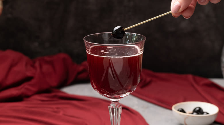 adding a cherry to cocktail