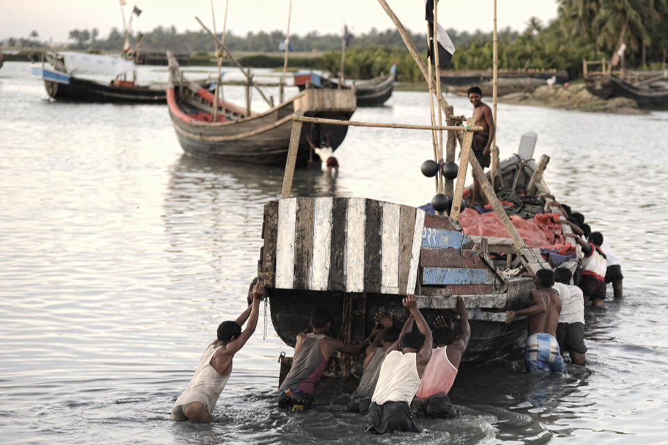 In this Nov. 28, 2013 photo, Rohingiya men push their boat to deeper waters in a lagoon close to the The' Chaung refugee camp on the outskirts of Sittwe, Myanmar. About 1.3 million Rohingya Muslims live in the predominantly Buddhist country of 60 million. Myanmar considers them illegal immigrants from neighboring Bangladesh, though some families have lived here for generations. (AP Photo/Kaung Htet)